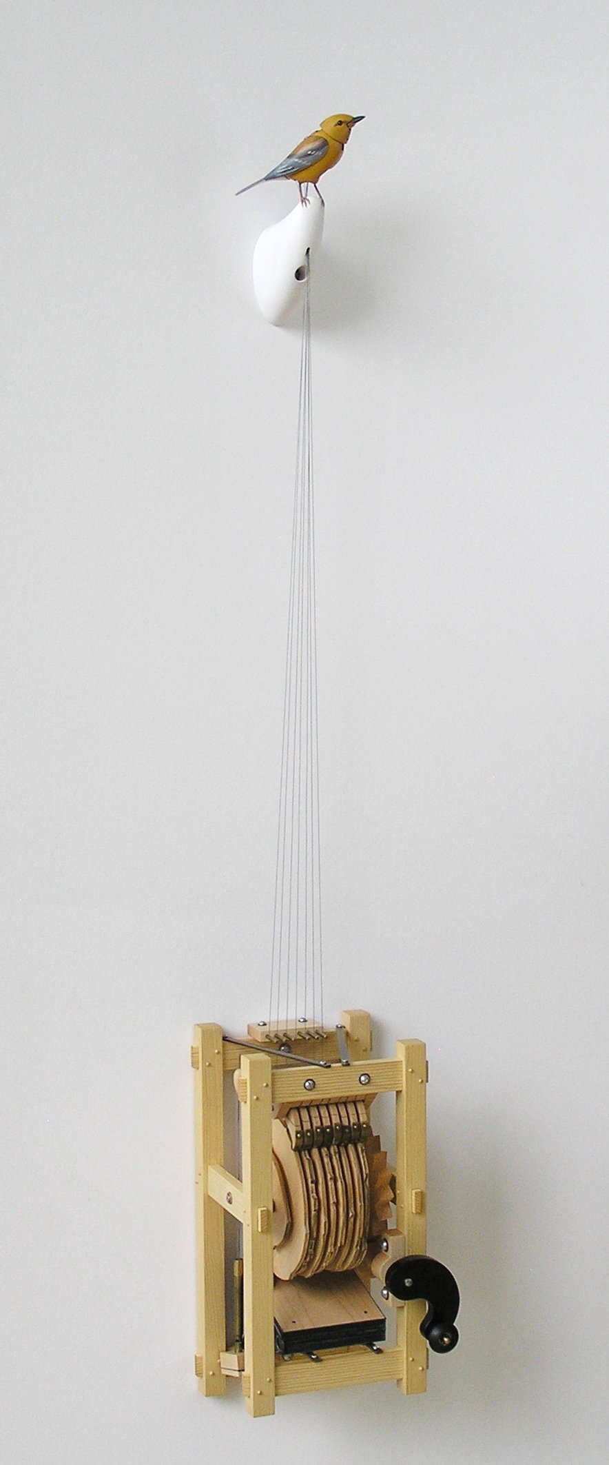Wooden gears, levers and metal fittings in the hand-cranked mechanism of Bliss Kolb’s wall-mounted singing bird.