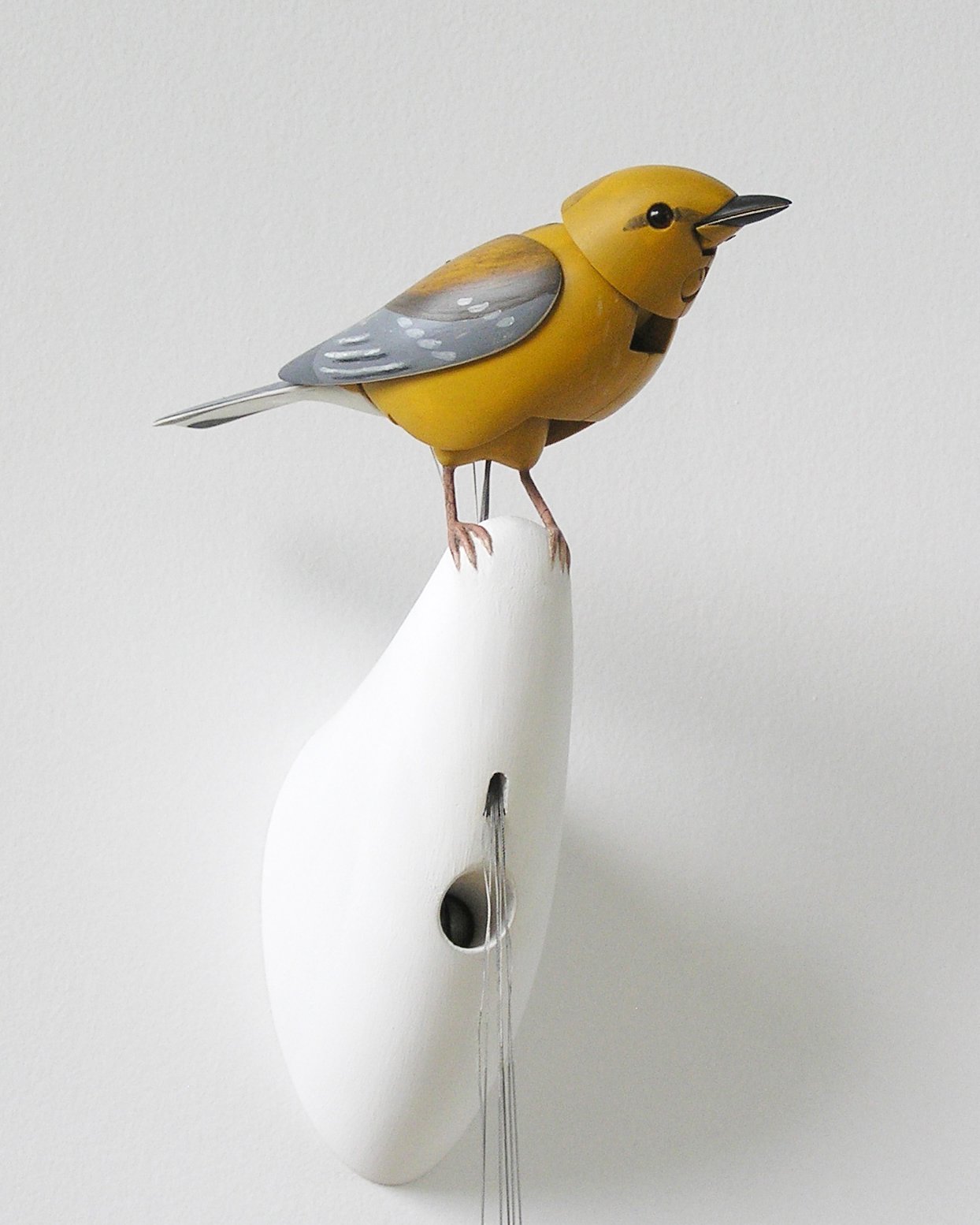 Bliss Kolb’s yellow wooden singing bird with a red crest, glass eye and metal fittings.