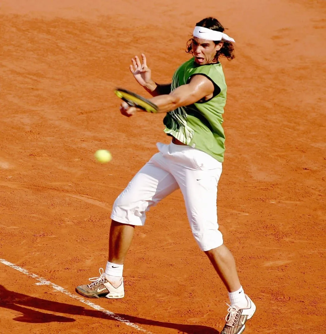 Archive: Rafael Nadal at Roland-Garros in 2005, wearing a green sleeveless top, white capri pants and a white bandana.